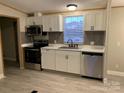 Modern kitchen with white cabinets and stainless steel appliances at 5204 Flay Rd, Cherryville, NC 28092