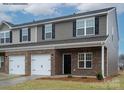 Two-story townhome with brick and siding, two-car garage, and front landscaping at 5156 Tommy Ln # 1301, Stanley, NC 28164