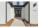 Front entry with double doors, white brick, and landscaping at 148 Windy Dell Dr, Tega Cay, SC 29708