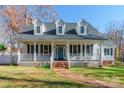 Two-story white house with a large front porch and brick walkway, surrounded by trees at 1882 Sardis Dr, Lancaster, SC 29720