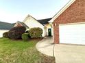 Side view of brick ranch home showcasing the attached garage at 2022 Galena Chase Dr, Indian Trail, NC 28079