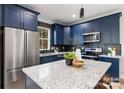 Modern kitchen with blue cabinetry, stainless steel appliances, and granite countertops at 310 Town St, Landis, NC 28088