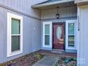 House entrance with maroon door and sidelights, small porch at 11324 Kingfisher Dr, Charlotte, NC 28226