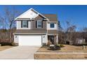 Two-story house with gray and brown siding, white garage door, and landscaping at 15533 Capps Rd, Charlotte, NC 28278