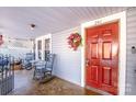 Red front door entry with rocking chairs on the porch at 241 4Th N Ave, Taylorsville, NC 28681