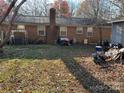 Large backyard with brick home and some yard clutter at 7008 Crossridge Rd, Charlotte, NC 28214