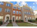 Three-story brick townhouses with front yards at 7111 Brighton Park Dr, Mint Hill, NC 28227