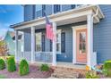 Inviting front porch with white columns and peach door at 9528 Gladden Hill Ln, Pineville, NC 28134