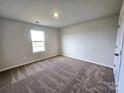 Spacious bedroom with neutral-toned carpet and large window at 211 Aniston Ln, Shelby, NC 28152