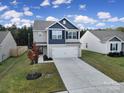 Two-story house with gray and blue siding, two-car garage, and landscaped lawn at 654 Lancelot Dr, Richburg, SC 29729