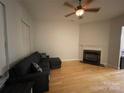 Spacious living room featuring hardwood floors, a cozy fireplace, and a comfortable sectional sofa at 104 Kensington St, Mooresville, NC 28117