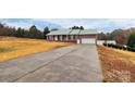 Brick ranch home with a green metal roof and a long driveway at 2945 Parks Lafferty Rd, Concord, NC 28025