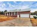 Brick ranch home with a green metal roof and attached garage at 2945 Parks Lafferty Rd, Concord, NC 28025