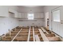 Unfinished kitchen with exposed subfloor and white cabinets at 1119 Poplar St, Albemarle, NC 28001