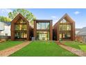 Contemporary three-unit building showcasing expansive windows and backyard at 4026 Chevington Rd # 101, Charlotte, NC 28226