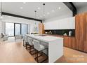 Modern kitchen with white and wood cabinets, island, and breakfast bar at 4026 Chevington Rd # 102, Charlotte, NC 28226