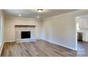 Bright living room with a whitewashed brick fireplace and hardwood floors at 507 Redah Ave, Locust, NC 28097