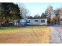 Tan mobile home with gray trim, new deck, and spacious yard at 5811 Monarch Pass, Claremont, NC 28610