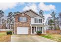 Two-story brick home with a white garage door and landscaping at 1061 Sundance Dr, Gastonia, NC 28054