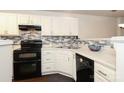 Modern kitchen with white cabinets, black appliances, and tile backsplash at 11015 Alderbrook Ln, Charlotte, NC 28270