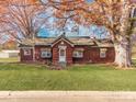 Red-sided house with a grassy yard and mature trees in autumn at 491 Lytton St, Troutman, NC 28166