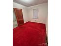 Simple bedroom with red carpeting and a window at 601 Sherman St, Badin, NC 28009