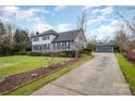 Two-story house with gray siding, a long driveway, and mature trees at 8823 Dartmoor Pl, Mint Hill, NC 28227