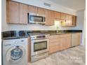 Stainless steel appliances and light wood cabinets in kitchen at 1300 Queens Rd # 303, Charlotte, NC 28207