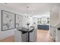 Open concept dining room with modern light fixture and gray chairs at 2023 Thurmond Pl # 14, Charlotte, NC 28205