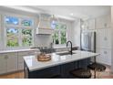 Modern kitchen with island, white cabinets, and black faucet at 2023 Thurmond Pl # 14, Charlotte, NC 28205