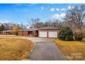 View of the red brick ranch home with attached two-car garage and driveway at 1755 N Main St, China Grove, NC 28023