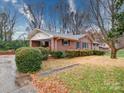 Charming brick ranch home with landscaped yard and autumn leaves at 7218 Melody Ln, Charlotte, NC 28214