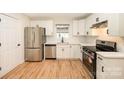 Modern kitchen with white cabinets, stainless steel appliances, and hardwood floors at 521 Colony Acres Dr, Charlotte, NC 28217