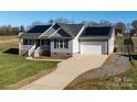 Gray house with solar panels, white garage door, and a landscaped lawn at 2498 Rock Dam Rd, Lincolnton, NC 28092