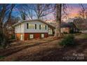 Side view of brick ranch home showcasing additional landscaping at 6108 Netherwood Dr, Charlotte, NC 28210