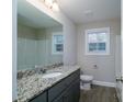 Clean and bright bathroom with granite countertop, modern fixtures, and wood-look flooring at 1014 Kansas St, Kannapolis, NC 28083