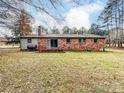 Brick house back view with deck, storage tank, and large yard at 313 Lake Montonia Rd, Kings Mountain, NC 28086