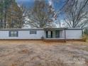 Front view of a single-wide manufactured home with covered porch at 44267 Yadkin Brick Rd, New London, NC 28127