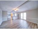 Open living room with vinyl flooring and kitchen access at 44267 Yadkin Brick Rd, New London, NC 28127