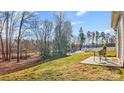 Spacious backyard with a concrete patio, a wicker chair, and natural views at 112 Tallow Ct, Mooresville, NC 28117