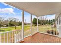 Inviting front porch with brick flooring and white railings, overlooking a spacious yard at 4264 C & B Farm Rd, Conover, NC 28613