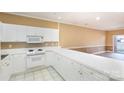 White kitchen with a breakfast bar and view to living room at 9315 Meadow Vista Rd, Charlotte, NC 28213