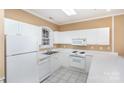 White kitchen cabinets, appliances, and tile floor at 9315 Meadow Vista Rd, Charlotte, NC 28213
