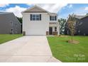 Two-story house with white siding, brown door, and a two-car garage. Nice curb appeal at 1009 20Th Avenue Se Loop, Hickory, NC 28602