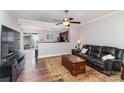 Living room with hardwood floors, leather sofa, and view of kitchen at 127 Morning Mist Ln # D, Mooresville, NC 28117