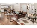 Open floor plan living room with hardwood floors, leather sofas, and a view of the kitchen at 3307 Tempo Ln, Indian Land, SC 29707