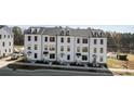 Row of three-story townhouses with white siding, and a pond in the background at 13009 Moon Rd # 42, Charlotte, NC 28277