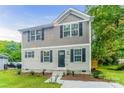 Two-story house with gray and beige siding, landscaping, and a concrete walkway at 358 Camden Nw Ct, Concord, NC 28027