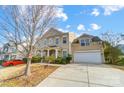 Beige two-story house with a white garage door and landscaping at 14217 Green Birch Dr, Pineville, NC 28134