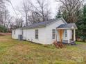 Side view of a single-story home with white siding and a yellow door at 208 Oakland Dr, Lowell, NC 28098